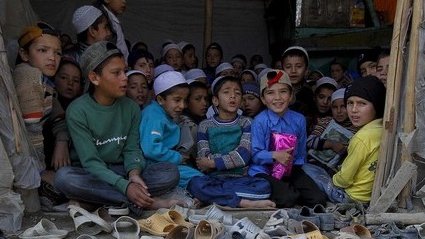 قرآن خوانی کودکان در یک دوکان، این کودکان باید زبان مادری شان را، ریاضی و...بخوانند
